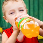Child drinking unhealthy bottled soda
