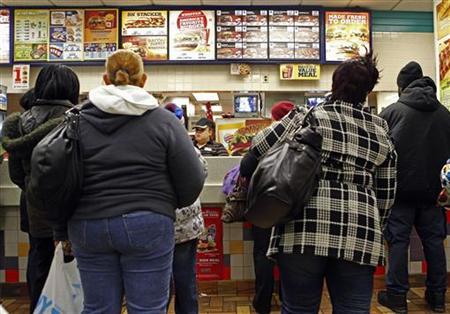 People line up to buy food at a fast food restaurant in Harlem in New York